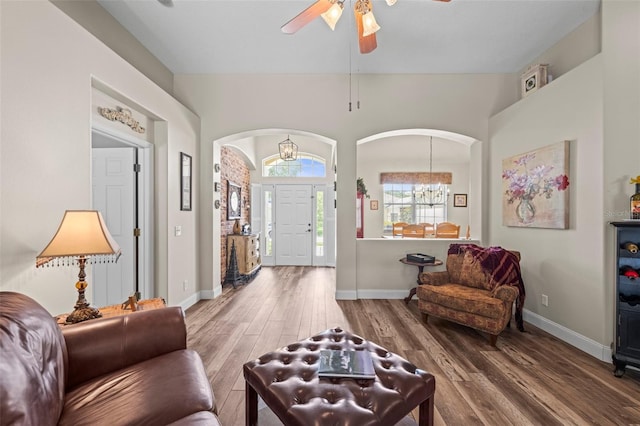743 Stonecrest Dr, Sarasota, FL 34232 - living area with arched walkways, a chandelier, wood finished floors, a ceiling fan, and baseboards
