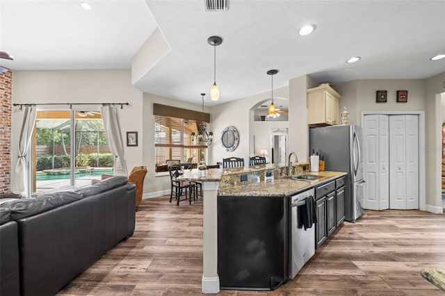 743 Stonecrest Dr, Sarasota, FL 34232 - kitchen with a sink, open floor plan, appliances with stainless steel finishes, wood finished floors, and recessed lighting