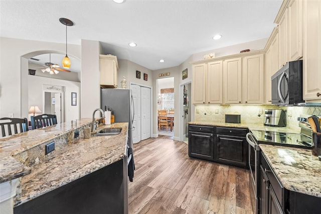 743 Stonecrest Dr, Sarasota, FL 34232 - kitchen featuring appliances with stainless steel finishes, cream cabinetry, a sink, dark cabinetry, and ceiling fan