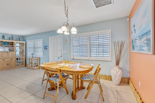 107 Van Dyck Dr, Nokomis, FL 34275 - dining room featuring a textured ceiling, a chandelier, and tile patterned floors
