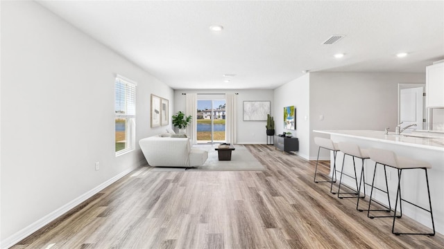 12064 Lansing Gln, Parrish, FL 34219 - living room featuring light wood-style floors, baseboards, and recessed lighting