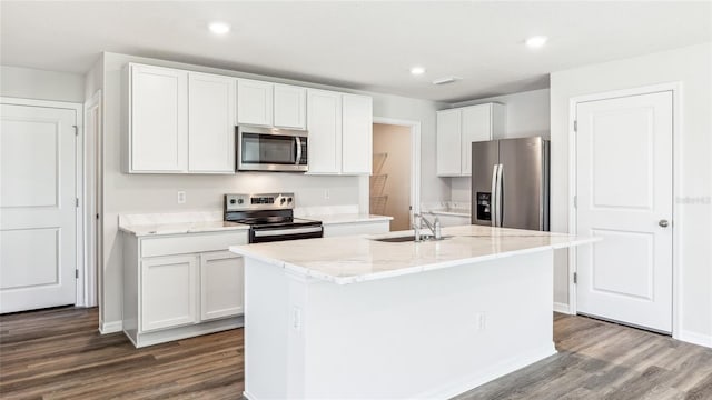 12064 Lansing Gln, Parrish, FL 34219 - kitchen with appliances with stainless steel finishes, dark wood-style flooring, a sink, white cabinetry, and an island with sink