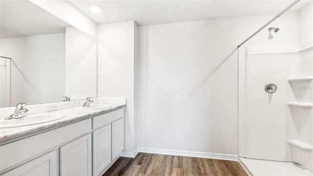 12064 Lansing Gln, Parrish, FL 34219 - full bath with wood finished floors, a shower, double vanity, and baseboards