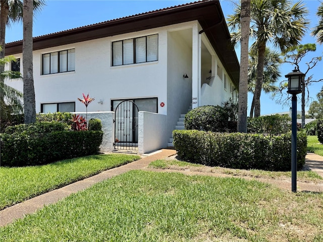 3500 El Conquistador Pkwy Unit 347, Bradenton, FL 34210 - view of front of house with stucco siding and a front lawn