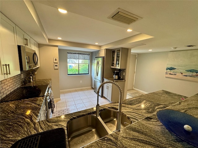 3500 El Conquistador Pkwy Unit 347, Bradenton, FL 34210 - kitchen with appliances with stainless steel finishes, glass insert cabinets, decorative backsplash, light tile patterned flooring, and recessed lighting