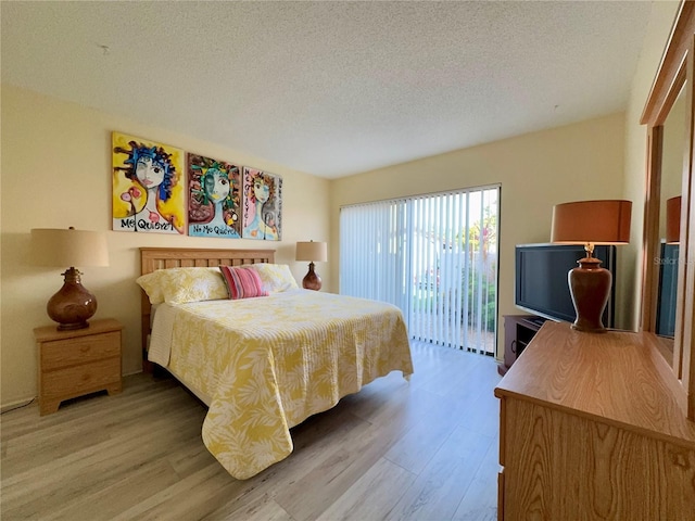 3500 El Conquistador Pkwy Unit 347, Bradenton, FL 34210 - bedroom featuring light wood-style flooring, access to outside, and a textured ceiling