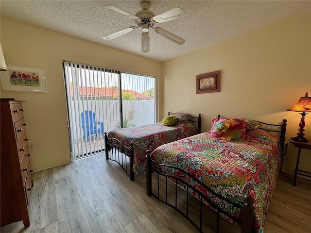 3500 El Conquistador Pkwy Unit 347, Bradenton, FL 34210 - bedroom with access to exterior, a textured ceiling, wood finished floors, and a ceiling fan