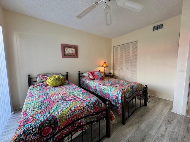 3500 El Conquistador Pkwy Unit 347, Bradenton, FL 34210 - bedroom with wood finished floors, a textured ceiling, a closet, and a ceiling fan