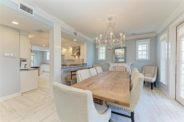 8963 Fishermens Bay Dr, Sarasota, FL 34231 - dining area featuring a chandelier, ornamental molding, and light wood finished floors