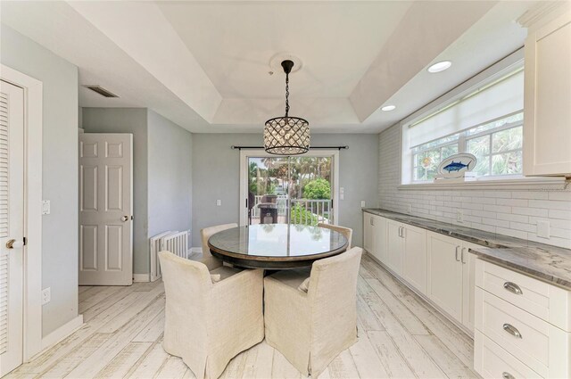 8963 Fishermens Bay Dr, Sarasota, FL 34231 - dining space with a tray ceiling, light wood-type flooring, plenty of natural light, a chandelier, and recessed lighting