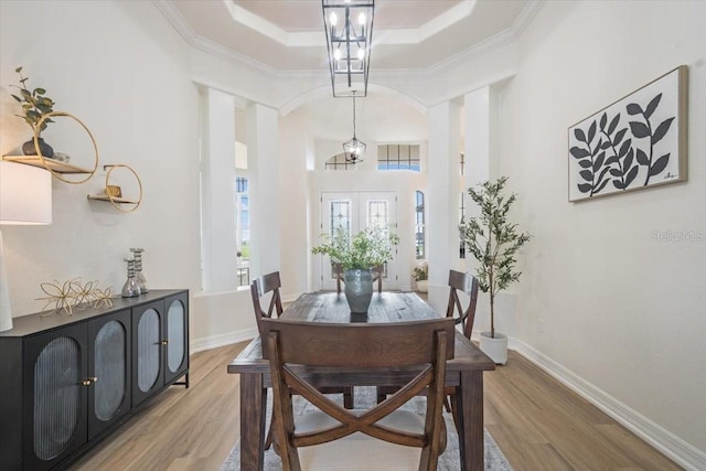 800 NW 36th Ave, Cape Coral, FL 33993 - dining space with a tray ceiling, light wood-style floors, ornamental molding, and baseboards