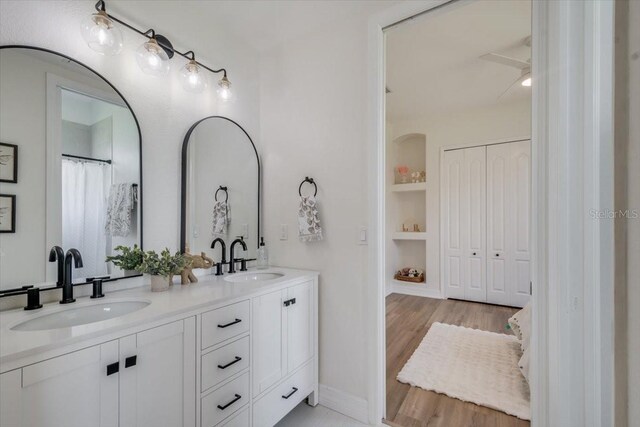 800 NW 36th Ave, Cape Coral, FL 33993 - full bathroom with double vanity, built in features, a ceiling fan, baseboards, and wood finished floors