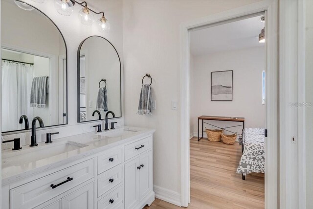 800 NW 36th Ave, Cape Coral, FL 33993 - bathroom with double vanity, wood finished floors, baseboards, and ensuite bathroom