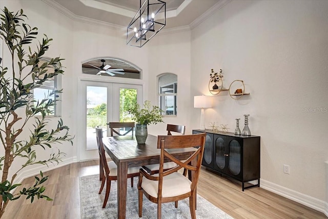 800 NW 36th Ave, Cape Coral, FL 33993 - dining room featuring light wood finished floors, french doors, a raised ceiling, ornamental molding, and a chandelier