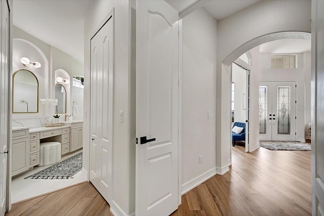 800 NW 36th Ave, Cape Coral, FL 33993 - hallway featuring arched walkways, light wood finished floors, healthy amount of natural light, and a sink