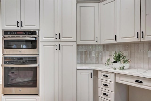 800 NW 36th Ave, Cape Coral, FL 33993 - kitchen featuring stainless steel double oven, white cabinetry, tasteful backsplash, and light stone counters