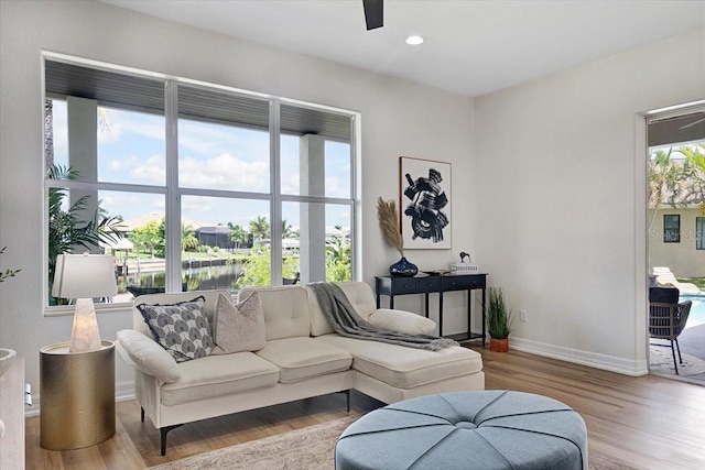 800 NW 36th Ave, Cape Coral, FL 33993 - living area with wood finished floors, baseboards, recessed lighting, a ceiling fan, and a water view