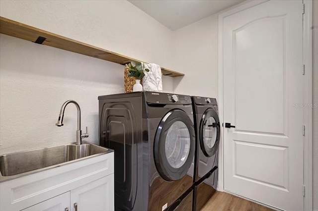 800 NW 36th Ave, Cape Coral, FL 33993 - laundry room featuring washing machine and dryer, light wood finished floors, and cabinet space