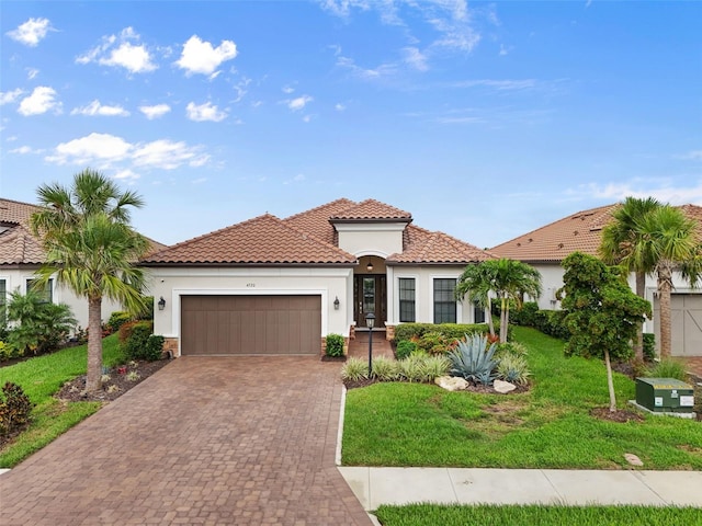 4720 Arpino Ct, Bradenton, FL 34211 - mediterranean / spanish-style house with a front yard, an attached garage, driveway, stucco siding, and a tile roof