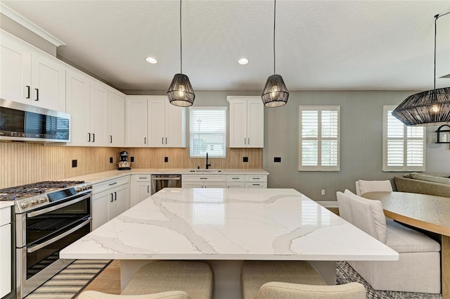 17898 Cherished Loop, Bradenton, FL 34211 - kitchen with appliances with stainless steel finishes, a sink, a breakfast bar area, healthy amount of natural light, and recessed lighting