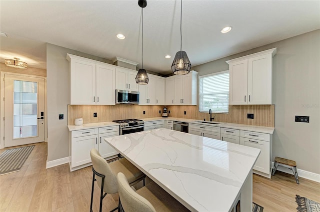 17898 Cherished Loop, Bradenton, FL 34211 - kitchen featuring stainless steel appliances, a sink, baseboards, light wood-type flooring, and decorative backsplash