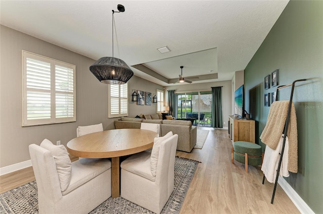 17898 Cherished Loop, Bradenton, FL 34211 - dining space featuring a raised ceiling, light wood-style floors, baseboards, and a ceiling fan