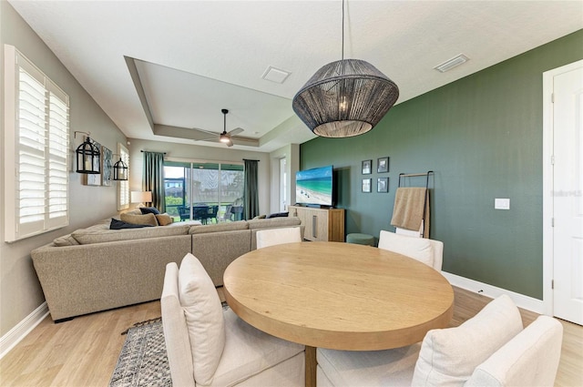 17898 Cherished Loop, Bradenton, FL 34211 - dining room with light wood finished floors, baseboards, a ceiling fan, and a tray ceiling