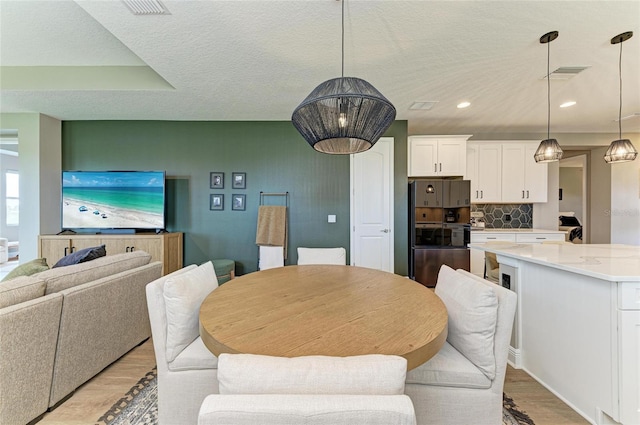 17898 Cherished Loop, Bradenton, FL 34211 - dining area featuring light wood-style flooring, a textured ceiling, and recessed lighting
