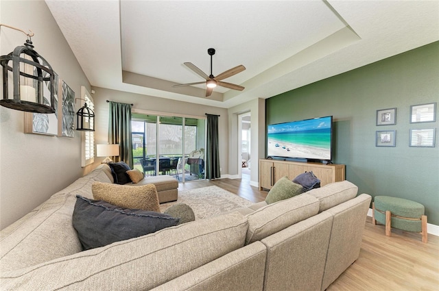 17898 Cherished Loop, Bradenton, FL 34211 - living area featuring light wood-type flooring, a tray ceiling, ceiling fan, and baseboards