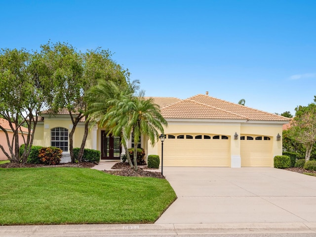 6811 Honeysuckle Trl, Lakewood Ranch, FL 34202 - mediterranean / spanish-style home with french doors, a garage, driveway, stucco siding, and a front yard
