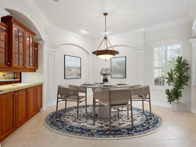 6811 Honeysuckle Trl, Lakewood Ranch, FL 34202 - dining room featuring ornamental molding, light tile patterned floors, ornate columns, and arched walkways