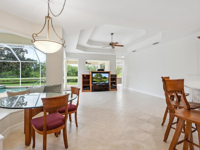 6811 Honeysuckle Trl, Lakewood Ranch, FL 34202 - dining room with a ceiling fan, a raised ceiling, light tile patterned floors, and a sunroom