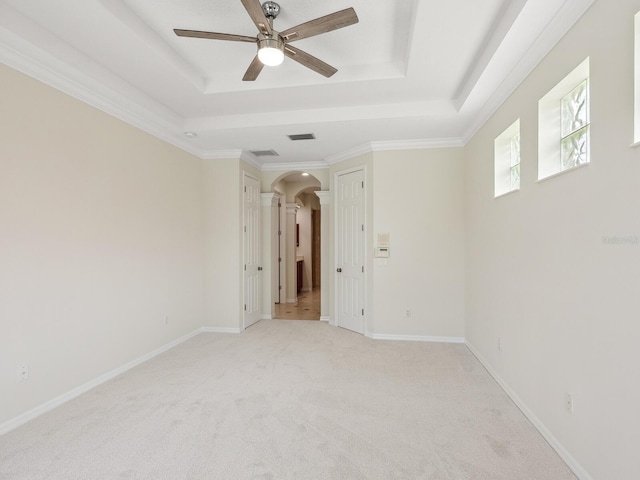 6811 Honeysuckle Trl, Lakewood Ranch, FL 34202 - unfurnished room with a tray ceiling, arched walkways, ceiling fan, and light colored carpet