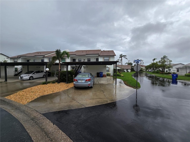 1211 Capri Isles Blvd Unit 116, Venice, FL 34292 - view of front of house with a residential view, a carport, and stucco siding