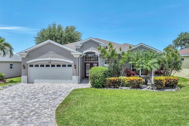 5142 51st Ln W, Bradenton, FL 34210 - ranch-style home featuring a garage, a front yard, stucco siding, and decorative driveway