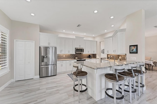 5142 51st Ln W, Bradenton, FL 34210 - kitchen featuring stainless steel appliances, a peninsula, light stone countertops, white cabinets, and recessed lighting