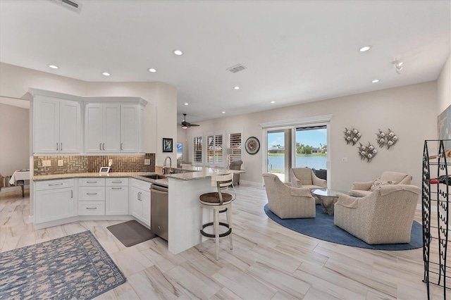 5142 51st Ln W, Bradenton, FL 34210 - kitchen with open floor plan, a peninsula, stainless steel dishwasher, white cabinetry, and recessed lighting
