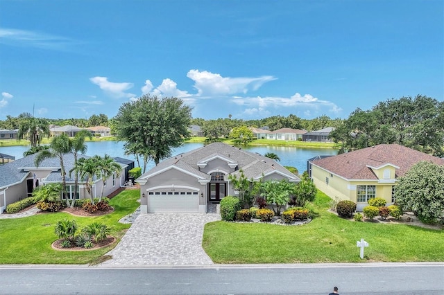 5142 51st Ln W, Bradenton, FL 34210 - view of front facade featuring an attached garage, a water view, a front yard, and decorative driveway