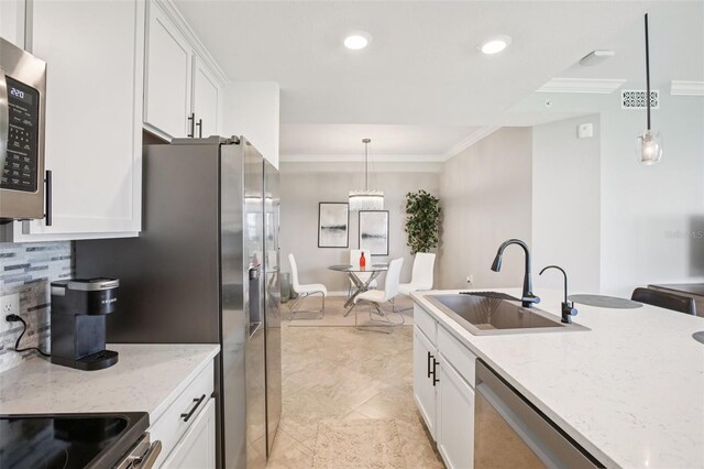 850 Tidewater Shores Loop Unit 108, Bradenton, FL 34208 - kitchen featuring a sink, stainless steel appliances, crown molding, white cabinetry, and tasteful backsplash