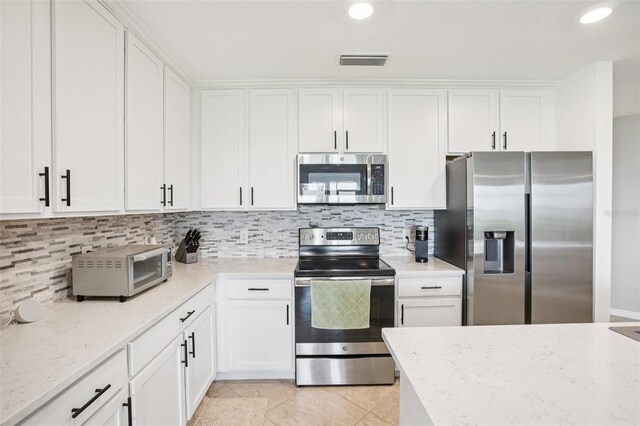 850 Tidewater Shores Loop Unit 108, Bradenton, FL 34208 - kitchen featuring stainless steel appliances, white cabinetry, backsplash, light stone countertops, and recessed lighting