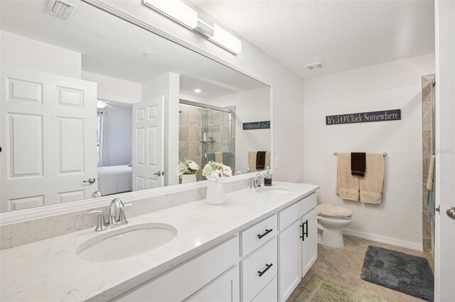 850 Tidewater Shores Loop Unit 108, Bradenton, FL 34208 - full bath with double vanity, a stall shower, toilet, a textured ceiling, and baseboards