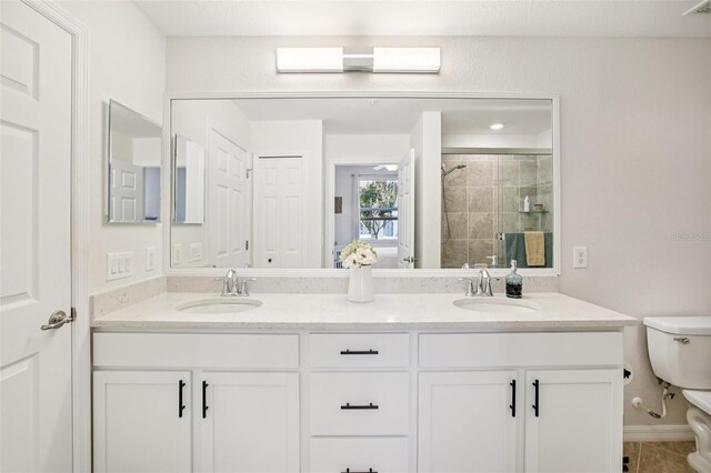 850 Tidewater Shores Loop Unit 108, Bradenton, FL 34208 - full bath featuring toilet, double vanity, a stall shower, and tile patterned flooring