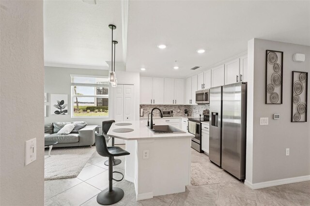 850 Tidewater Shores Loop Unit 108, Bradenton, FL 34208 - kitchen with appliances with stainless steel finishes, tasteful backsplash, a kitchen breakfast bar, white cabinetry, and a sink