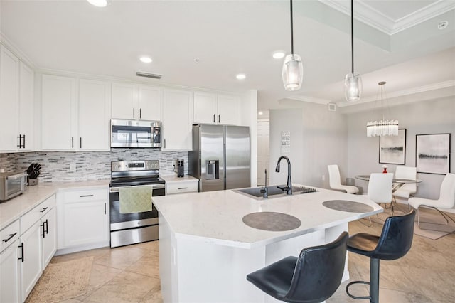 850 Tidewater Shores Loop Unit 108, Bradenton, FL 34208 - kitchen featuring stainless steel appliances, a sink, ornamental molding, tasteful backsplash, and white cabinetry