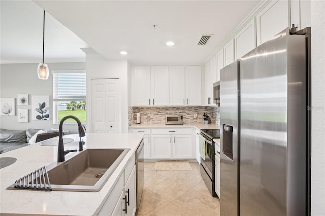850 Tidewater Shores Loop Unit 108, Bradenton, FL 34208 - kitchen featuring stainless steel appliances, a sink, decorative backsplash, white cabinets, and hanging light fixtures