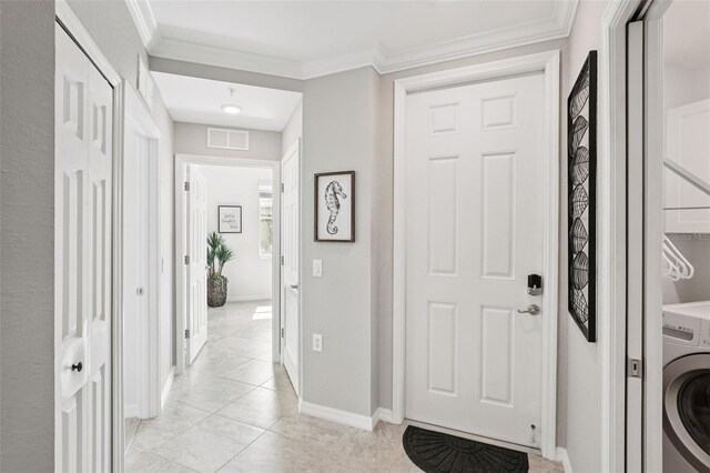 850 Tidewater Shores Loop Unit 108, Bradenton, FL 34208 - entryway featuring washer / dryer, baseboards, light tile patterned floors, and crown molding