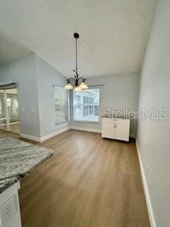 4811 14th Ave E, Bradenton, FL 34208 - unfurnished dining area with healthy amount of natural light, wood finished floors, and a chandelier