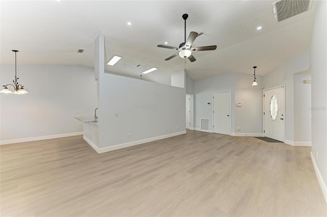 4811 14th Ave E, Bradenton, FL 34208 - unfurnished living room featuring vaulted ceiling, light wood finished floors, a ceiling fan, a chandelier, and recessed lighting