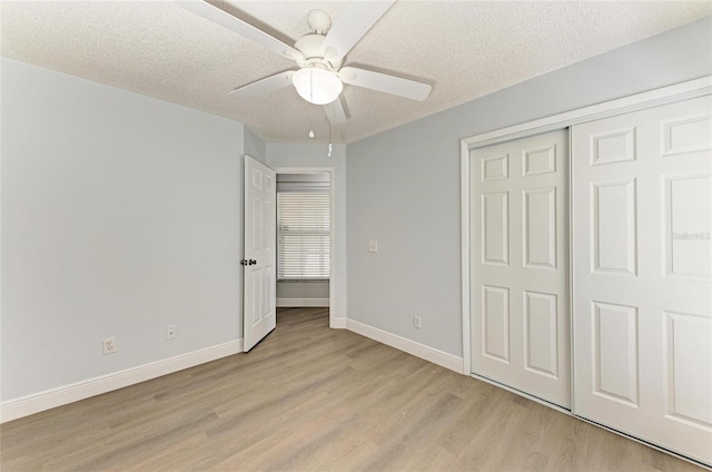 4811 14th Ave E, Bradenton, FL 34208 - unfurnished bedroom featuring light wood finished floors, a textured ceiling, a closet, and ceiling fan