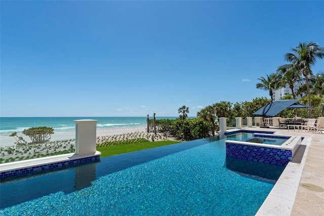 845 Longboat Club Rd, Longboat Key, FL 34228 - view of swimming pool with view of water and beach, a patio area, and a pool with connected hot tub
